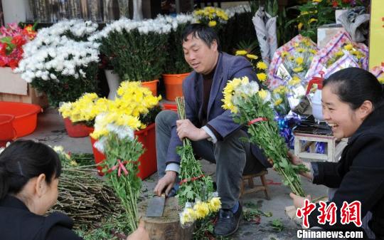 江西省德兴市银城镇一鲜花店，一把把用于扫墓祭奠的鲜花映衬着经销商开心的笑脸。卓忠伟 摄