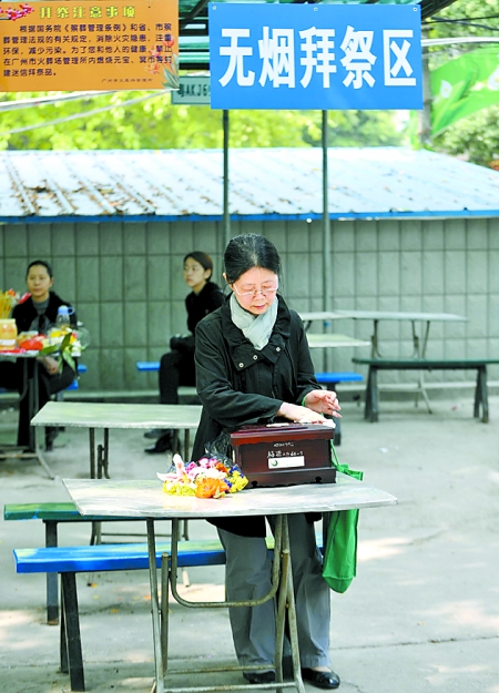 4月2日,一位市民在广州市火葬场无烟拜祭区擦拭逝者的骨灰盒.