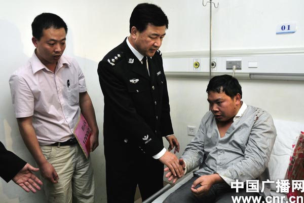 厦门市副市长、公安局长王小洪到医院看望因见义勇为而受伤的市民王兵