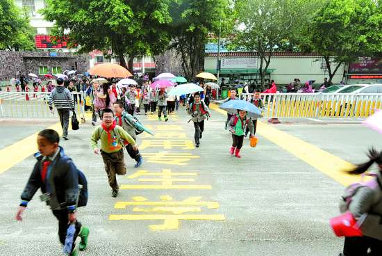 4月16日,学生放学后迅速从学生专用通道过街.