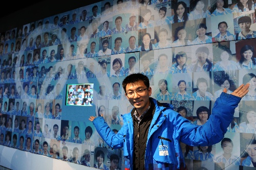 图文:揭秘伦敦奥运会志愿者 在志愿者墙前留影