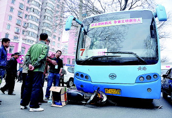 摩托车卷进公交车底,真险!(图)