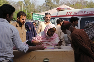 4月21日，在巴基斯坦首都伊斯兰堡附近，遇难者家属在辨认尸体。新华社发