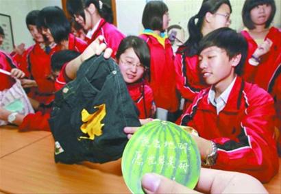 在沈阳二中，高二学生马杰夫（右）和同学们展示着用旧牛仔裤等制作的环保购物袋。 记者 姜旭 摄