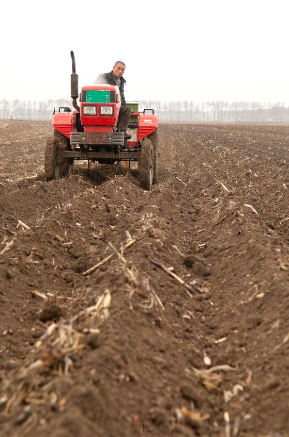 4月22日,在吉林德惠朱城子镇,一名农民驾驶拖拉机在犁守施肥.
