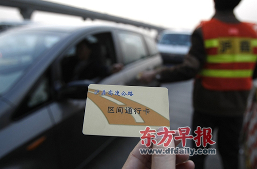 2009年3月16日,沪嘉高速公路主线收费站,工作人员在道口收取区间通行