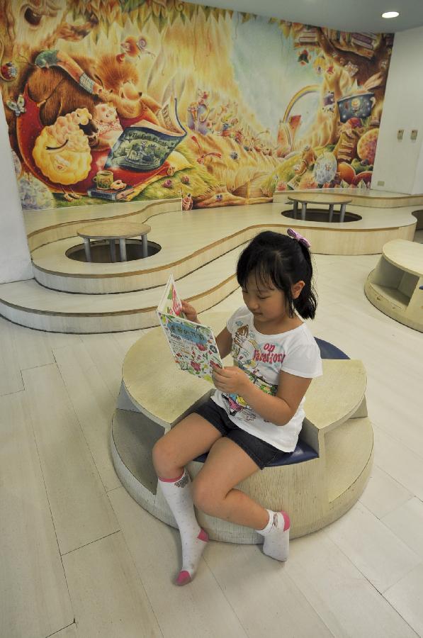 新华社】; 一名女孩在图书馆的儿童阅览室内看书; 图书与空间:台北市