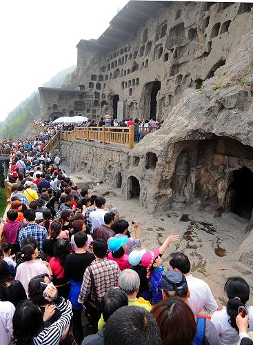 大批游客涌入洛阳龙门石窟景区参观游览（2012年4月21日摄）。新华社记者 王颂 摄