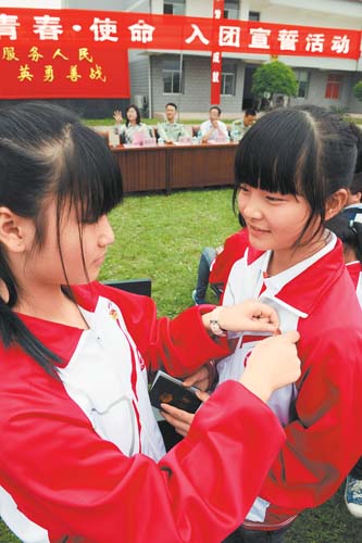 南昌市桃花学校新团员接受老团员佩戴团徽(图)