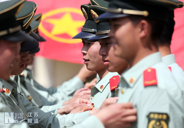 武警江苏总队一支队的青年官兵互相佩戴团徽