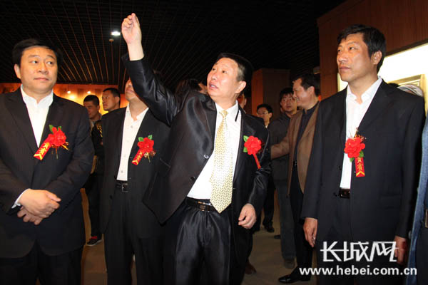 展出现场,王凤国为嘉宾借读绘画技法和喻意. 长城网 席亚楠 摄