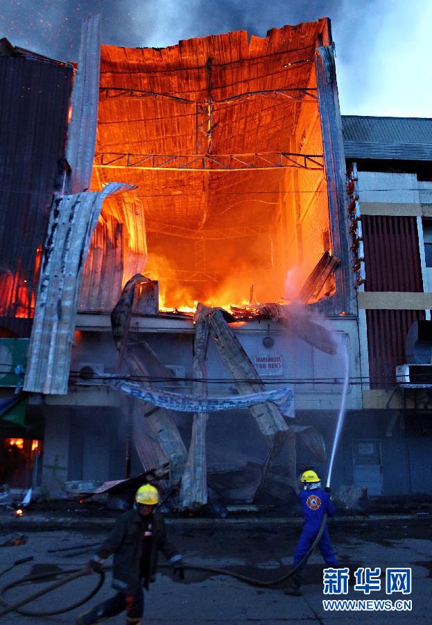 武端市 北阿古桑/5月9日，在菲律宾南部北阿古桑省武端市，消防员在火场救火。