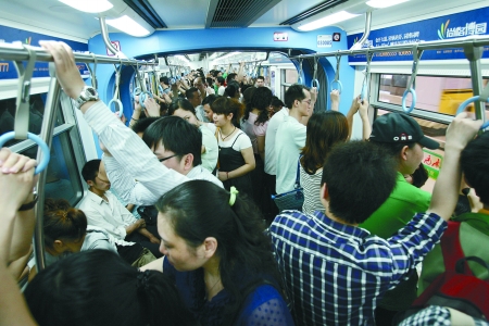 高峰期轻轨车厢内很拥挤,车厢中部相对比较宽松. 记者 张永波 摄