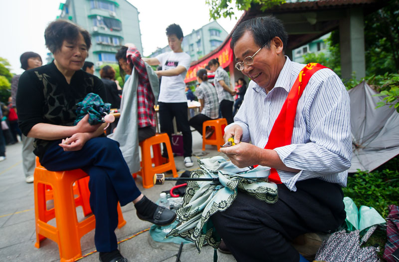 5月15日,志愿者在给社区居民提供免费修伞,理发等服务.