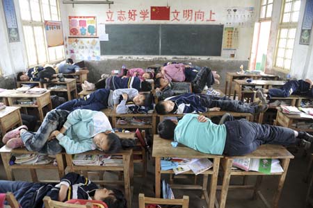 区雷打石镇砖桥学校小学六年级教室,学生把课桌,凳子当床,睡得正香