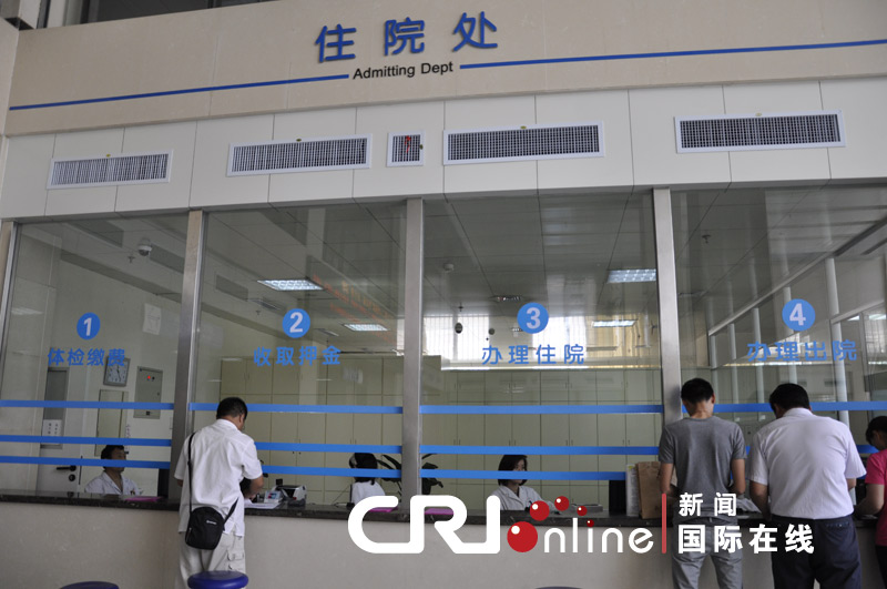 济宁市第二人民医院门诊大厅，显著位置电子屏关于“先看病，后付费”的提示。
