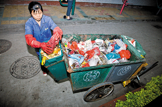 4月2日晚,海珠区环卫工人徐阿姨将厨余垃圾从繁杂的垃圾堆里挑选出来.