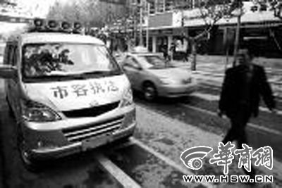 没有挂牌子的“市容执法”车在街道上随意停放 本报记者 魏光敬摄