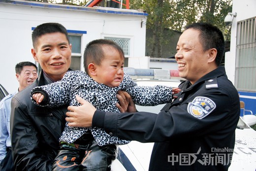 50-1 2011年10月，蒋赵云抱着哭闹着找警察叔叔的蒋科豪，右一为仙居公安局重案组指导员吴明。由于失散太久，蒋科豪已经不认识父亲了。图/ 受访者提供