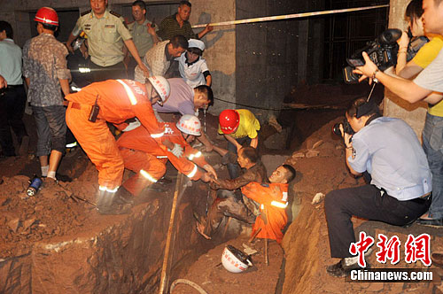 5月21日9时50分，重庆双桥一在建工地地下水槽突遇塌方，造成施工工人2名被卡在巨石下。消防官兵将被埋人员救出废墟。吴飞 摄