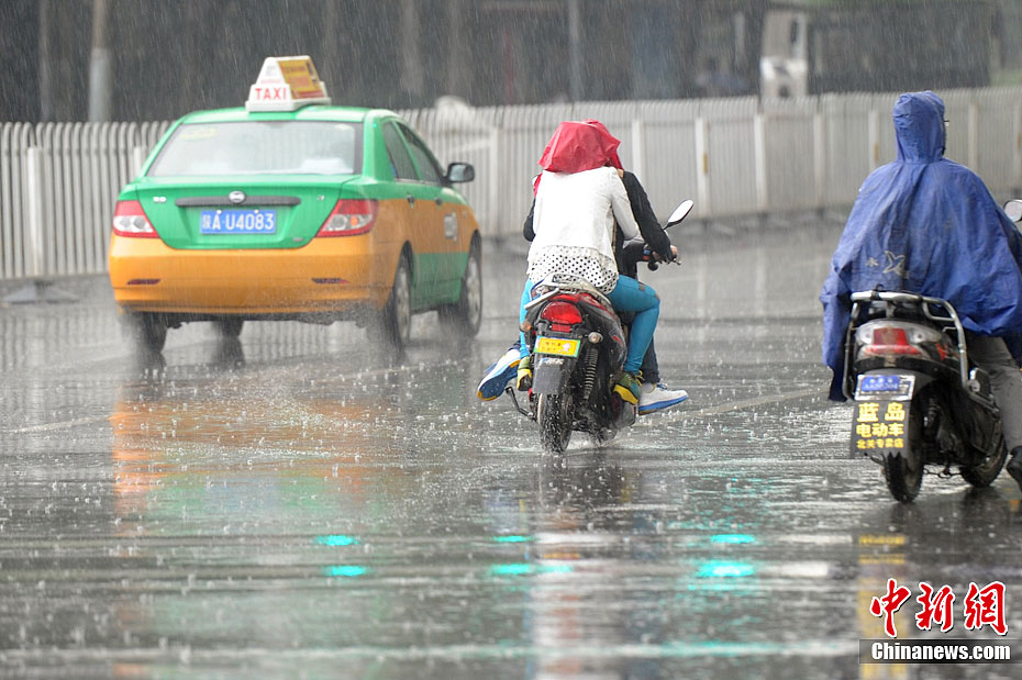 24日下午,一场来势汹汹的大雨"冲洗"着西安市的大街小巷,路上的行人