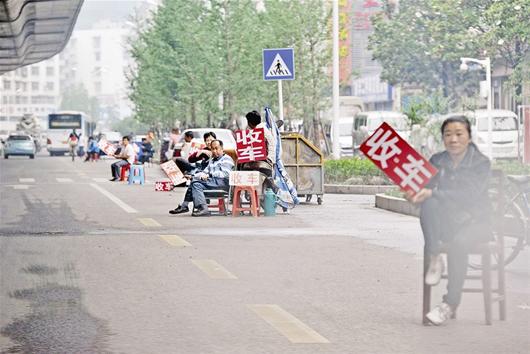 驾车经过二环线汉口常码头引桥处的汉西二手车市场两侧时,众多贩子打