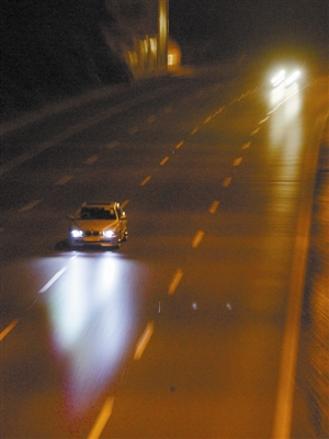 深夜的滨海大道上，车辆少，不少车开大灯急速飙车。