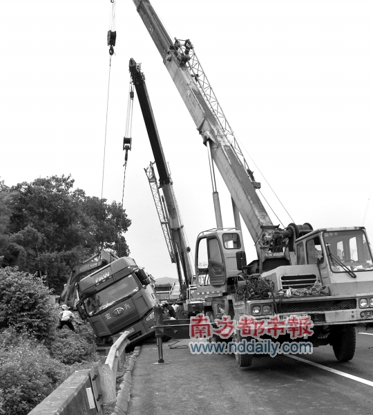 两辆吊车吊着货车,挖掘机正在将陶瓷泥挖出.南都记者刘学摄