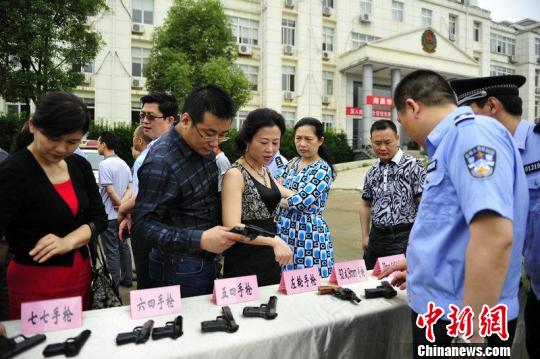 6月1日，“南昌市公安机关规范执法警营开放日”在南昌经开区举行。图为警官向参与者介绍警用枪械。胡坚 摄