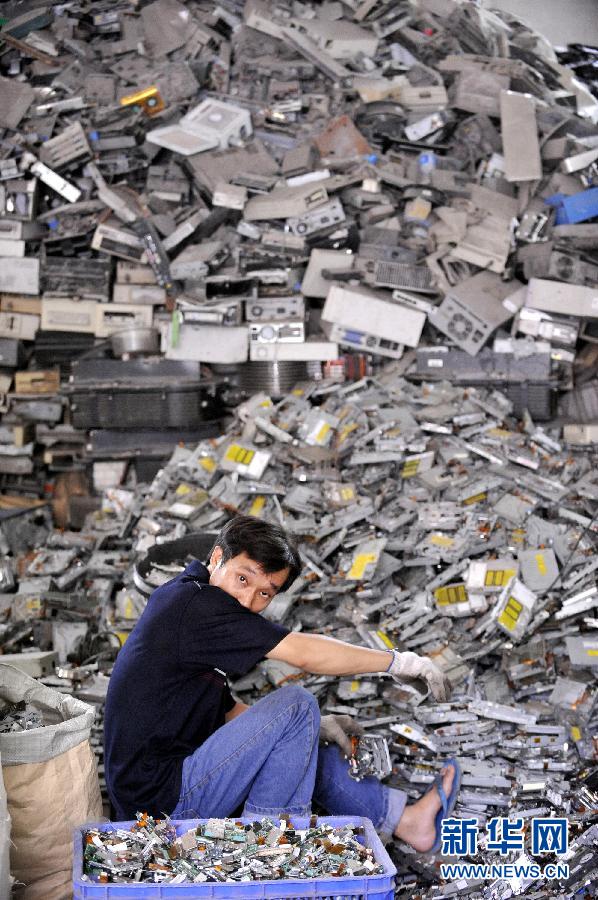 在广东汕头贵屿镇一家拆解电子垃圾的厂房里,工人用最原始的方法对