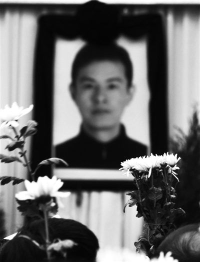 追悼会现场，吴斌遗像前摆满菊花。