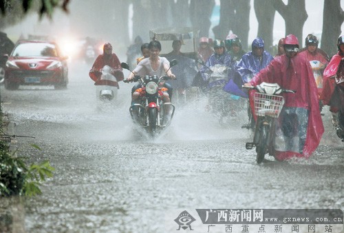 图为12日14时许，南宁市突降大暴雨，车流通过积满水的星光大道。记者 唐辉吉摄