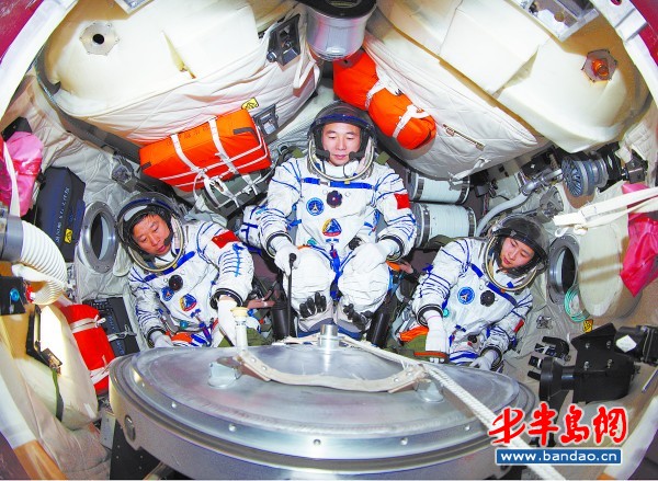 神舟九号航天员乘组景海鹏(中),刘旺(左),刘洋(右)在模拟返回舱进行