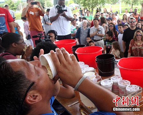 当地时间6月16日,参加美国亚太裔传统节吃面条比赛的选手正在奋力吃面。中新社发 王欢 摄