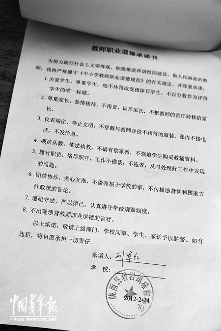 刘军红签字的教师职业道德承诺书。本报记者 张鹏摄