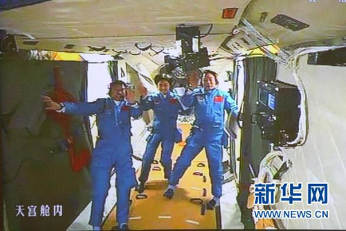 6月18日拍摄的北京航天飞控中心大屏幕显示的航天员景海鹏、刘旺、刘洋在天宫一号实验舱内的画面。 新华社记者 查春明 摄