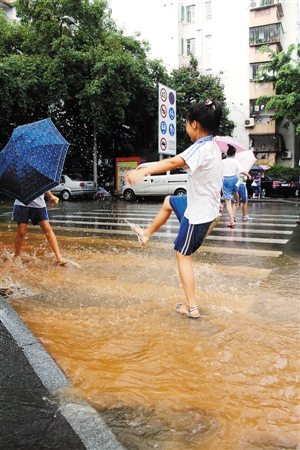 莲花路上不少小学生趁机玩水. 深圳晚报记者 梁尹星 摄