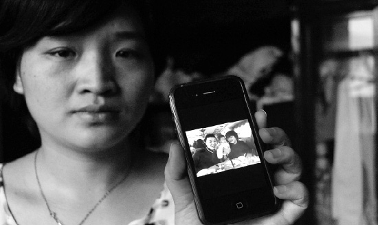 妻子何�|拿出了手机，里面是朋友随手拍的一张照片，这竟成了吴连表一家三口唯一的一张全家福。