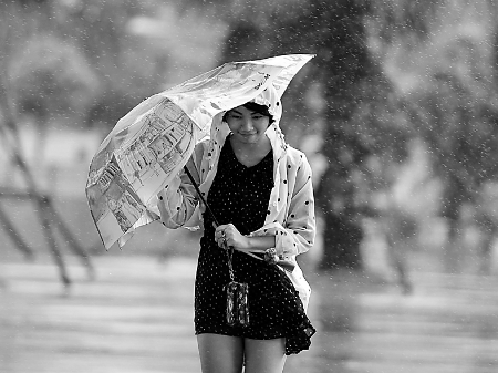 6月17日,海口市民在雨中行走.