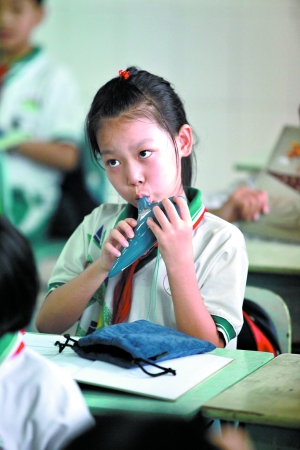 龙涛学校小学生兴致勃勃学吹陶笛。