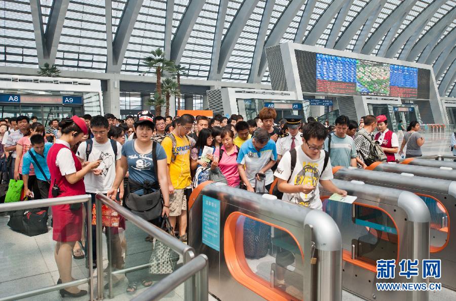 7月1日,乘客在天津西站检票进站上车.