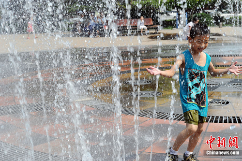 7月2日,山西太原,儿童在喷泉周围戏水享清凉.中新社韦亮摄影