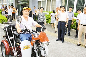 残疾人代表高兴地开走崭新的机动轮椅车.