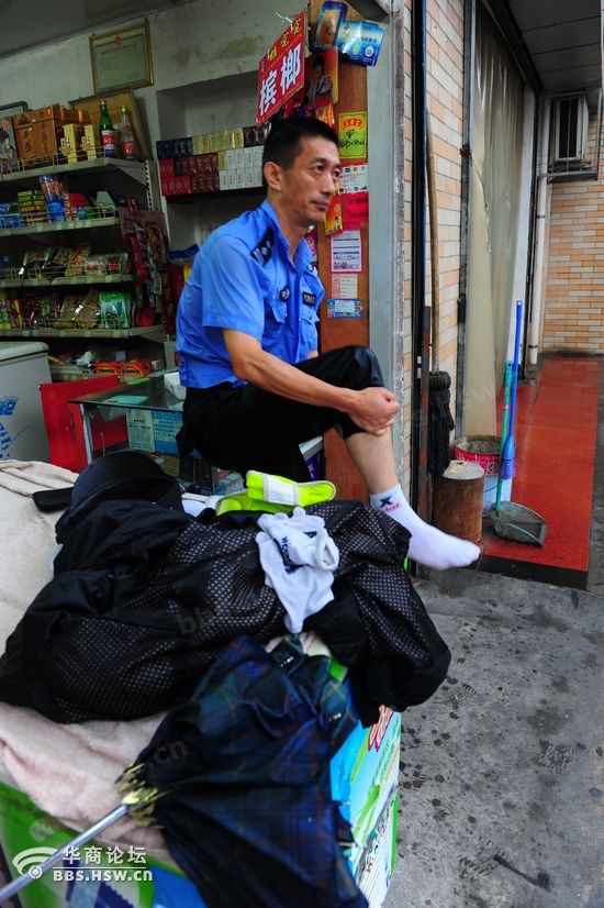 这位全身淋湿的交警拧干衣服上的雨水,倒掉了鞋子里的水.