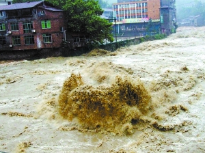 7月4日,四川省达州万源市庙沟河畔的房屋被洪水围困.新华社发