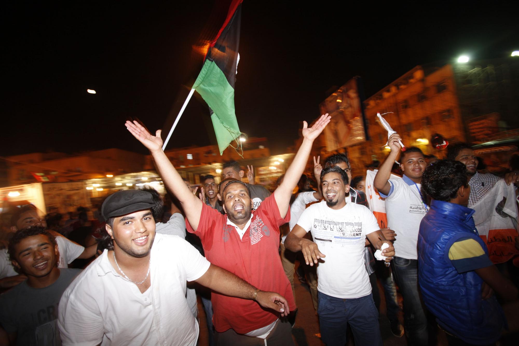 自由/在的黎波里的烈士广场，人们挥舞着利比亚新国旗。