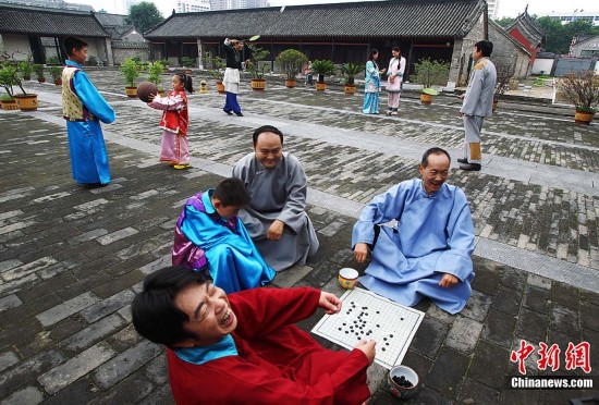 7月8日,河南南阳,南阳旅游局局长带领几位副局长在微电影拍摄现场客串群众演员集体“跑龙套”,这几个局长有的客串群众在下棋,有的则客串叫花子在现场做配角。