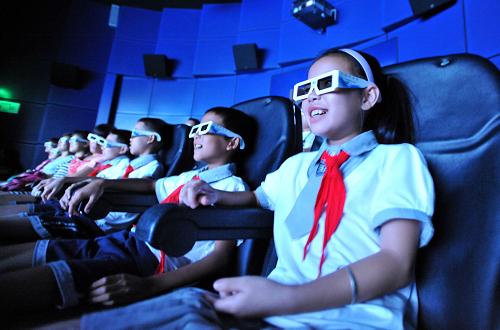 7月10日，在广西科技馆，几名来自广西柳州市融安县大坡乡岗伟村小学的留守儿童在观看高科技电影。新华社记者 陆波岸 摄