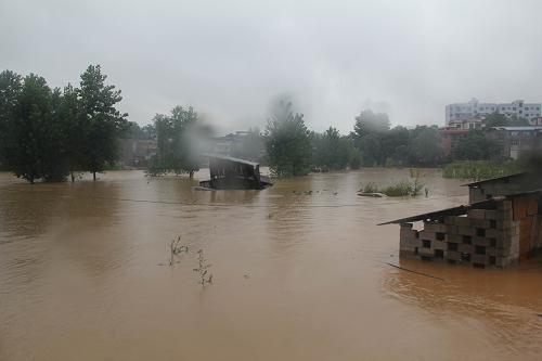 7月16日，铜仁碧江区谢桥邱家寨被洪水围困。新华社发（刘勇刚 摄）