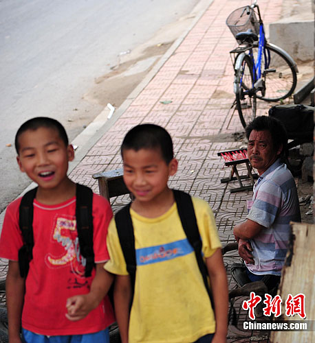 目送双胞胎儿子去学校，路建新总是感觉虽苦尤甜。胡影 摄